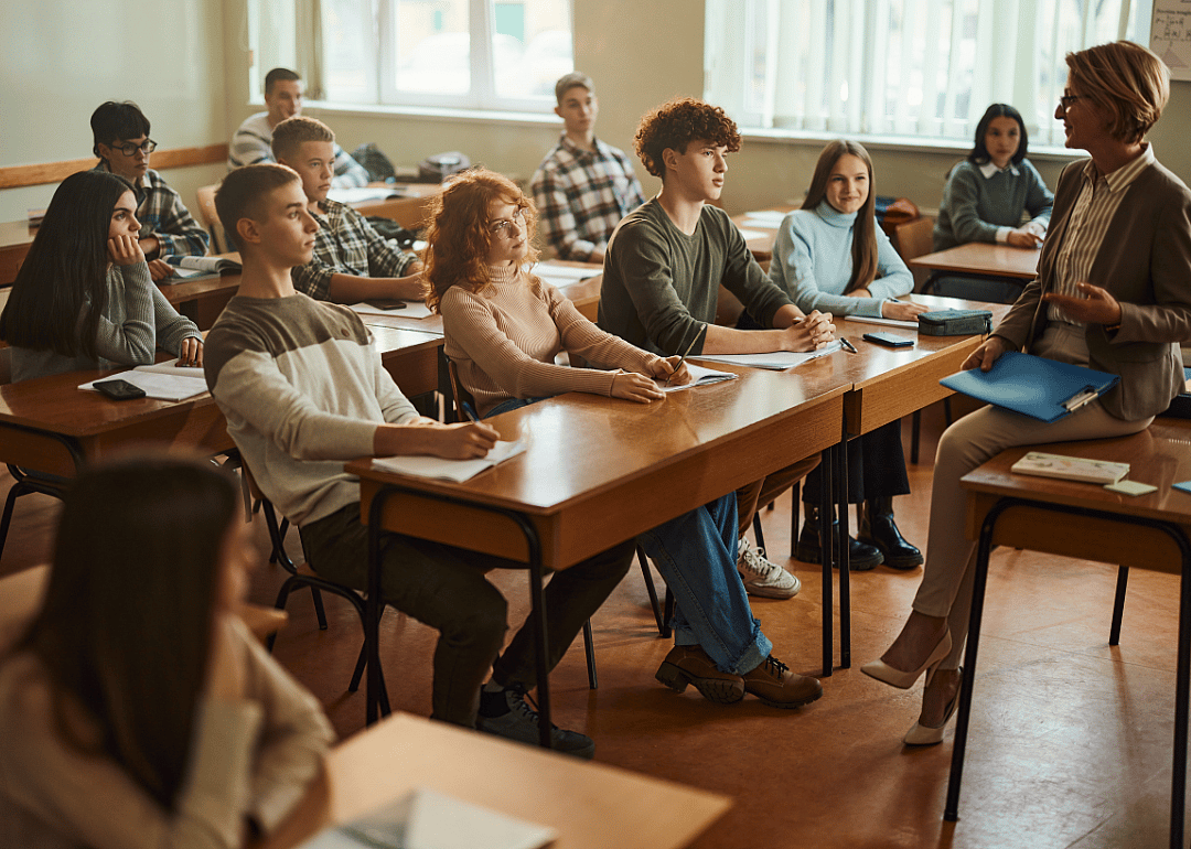 A high school class listening to their teacher.