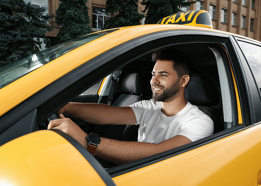 A taxi driver in their car.