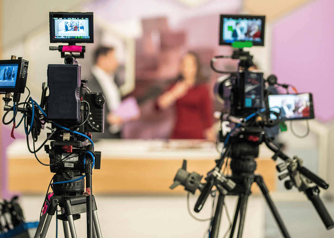 Two cameras filming a television show.