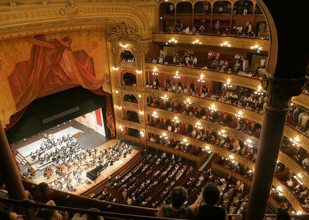 An orchestra performing in a larger theater.