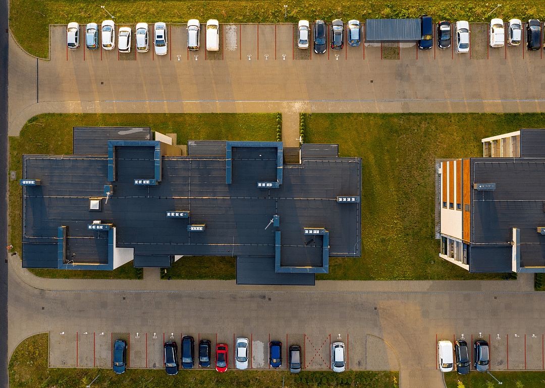 An aerial view of multifamily housing units with cars parked outside.