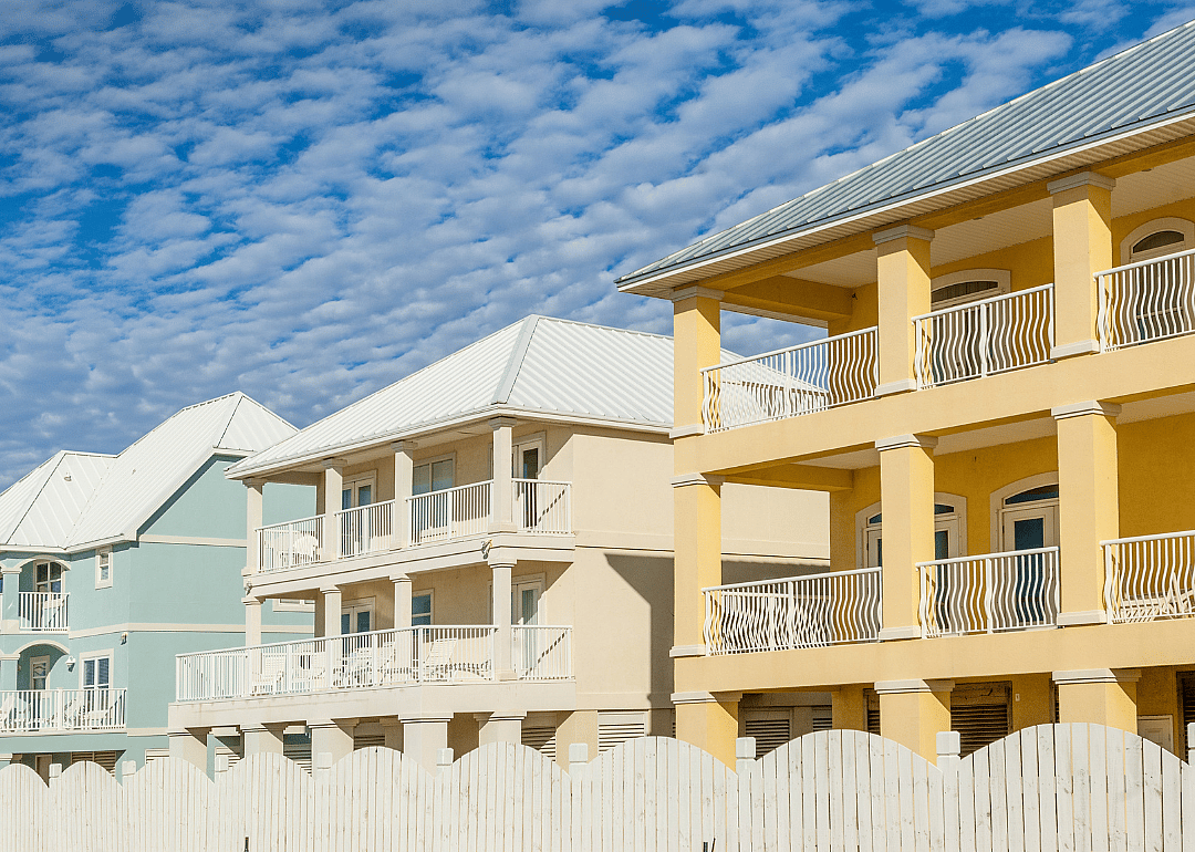 New construction oceanfront multicolored vacation homes on the white sandy beach of Gulf of Mexico in Alabama.