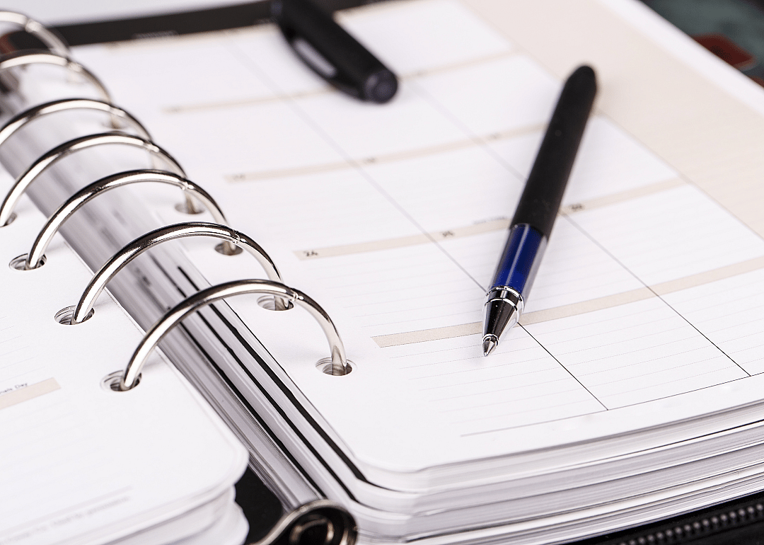 A blank calendar with a pen sitting on top of it.