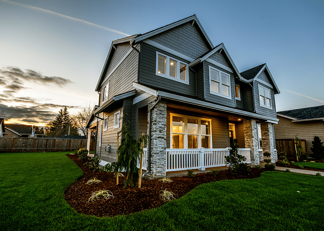 A modern home with its porch lit at sunset in Oregon.