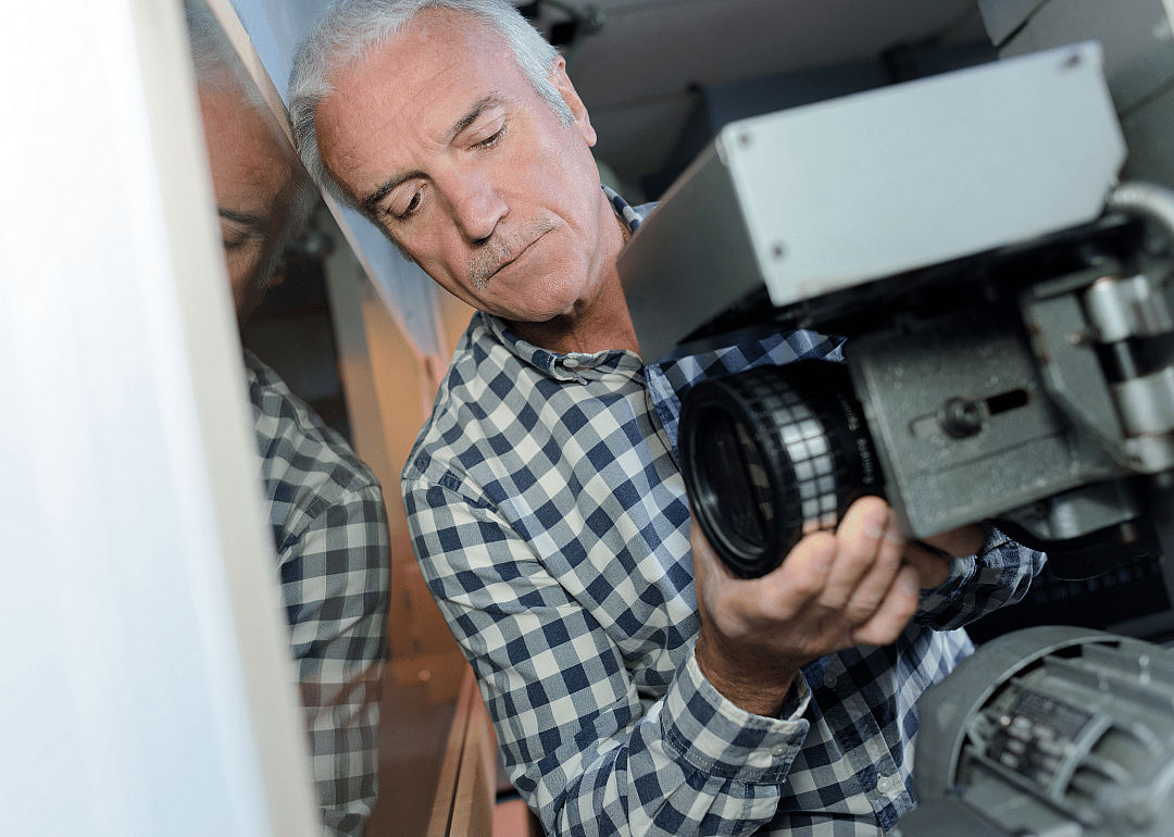 A motion picture projectionist at work.