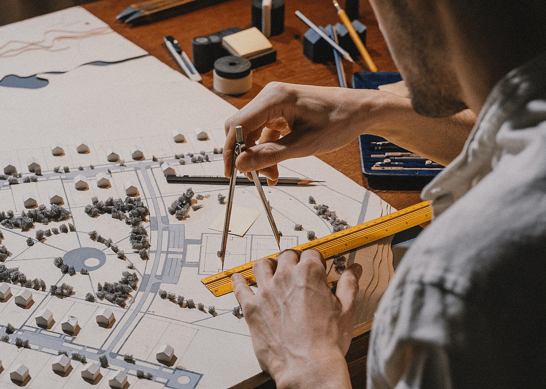 An architect taking measurements using a model.