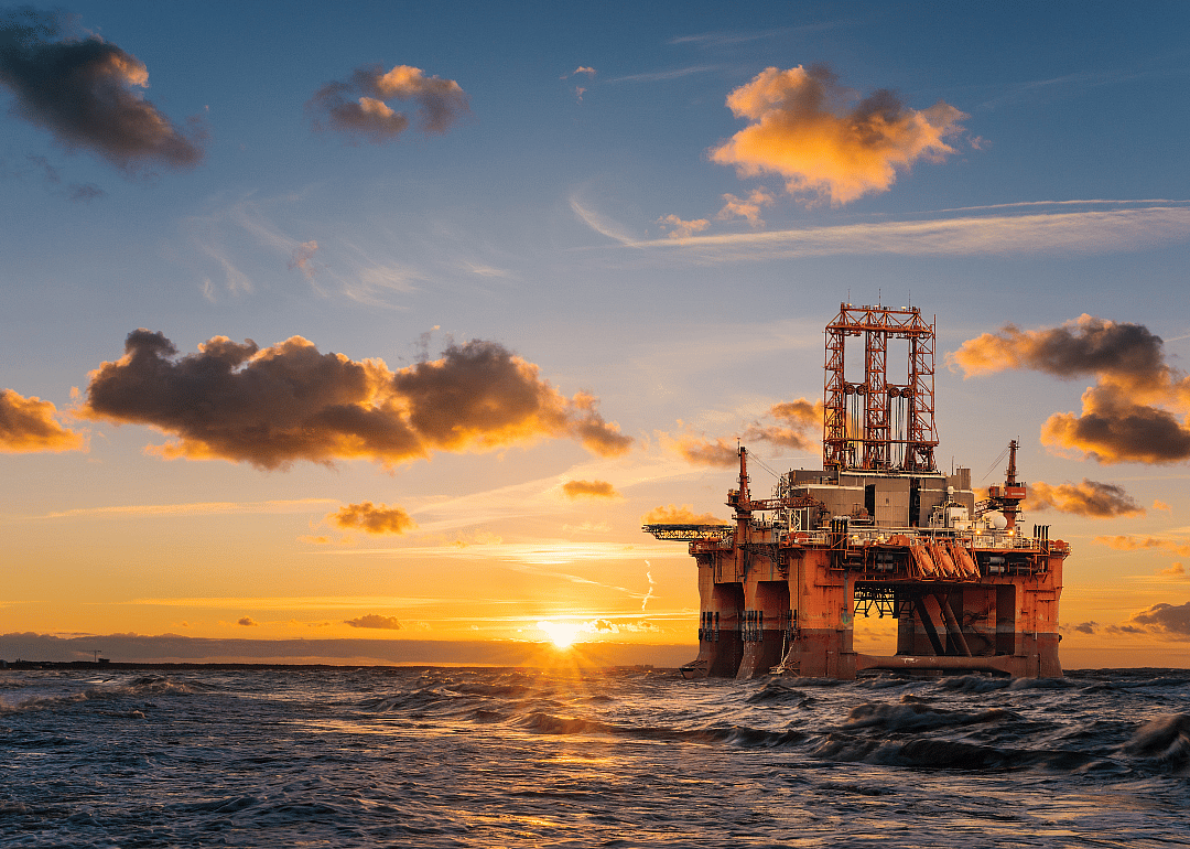An offshore oil rig at sunset.