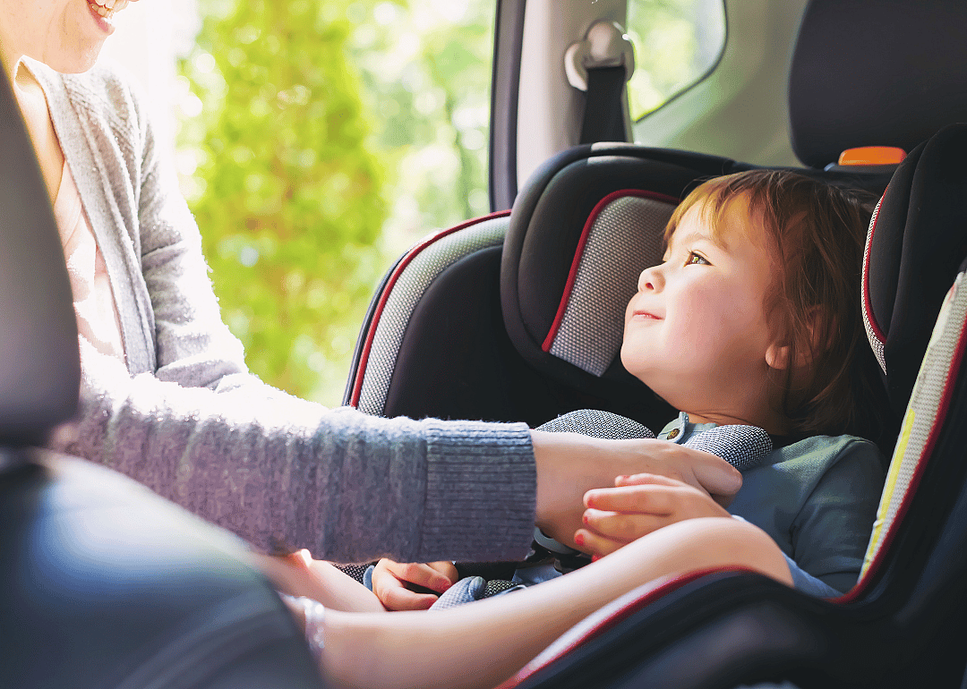A toddler strapped into a car seat.