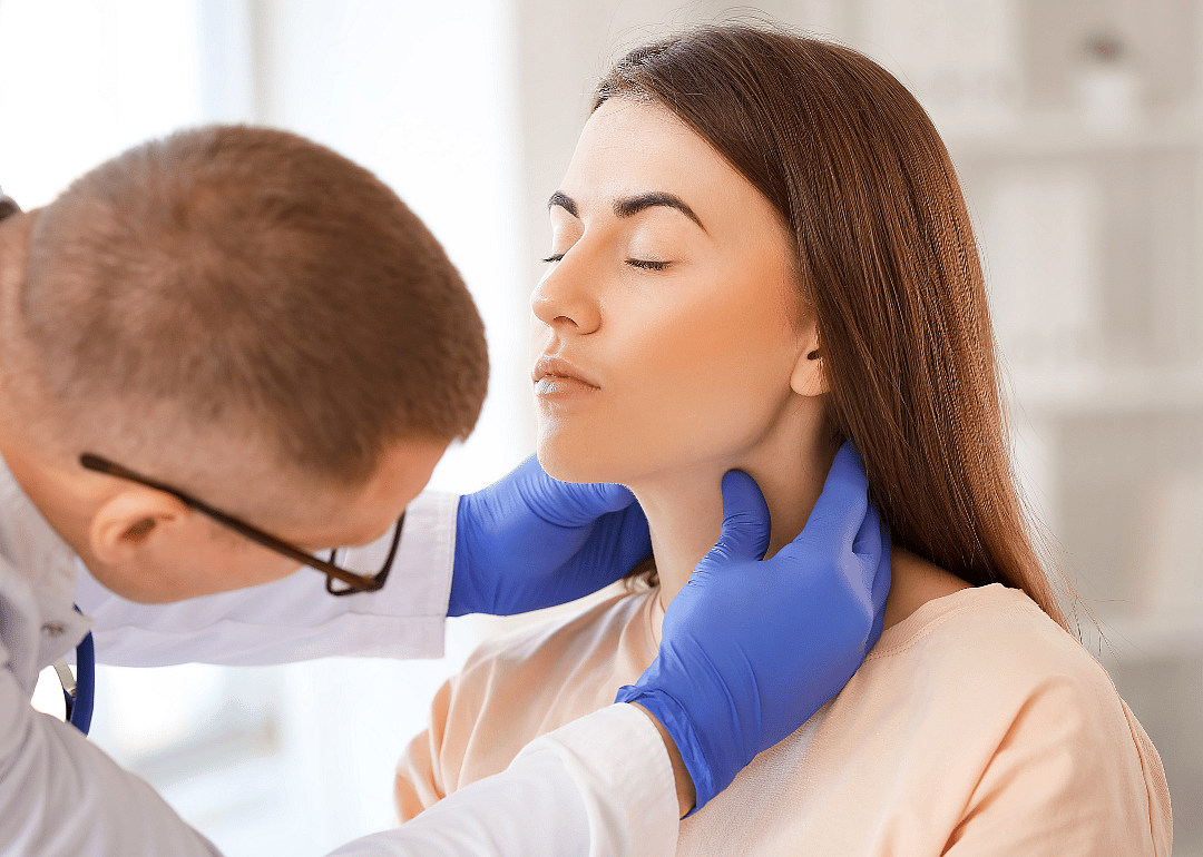 An endocrinologist inspecting a patient's throat.