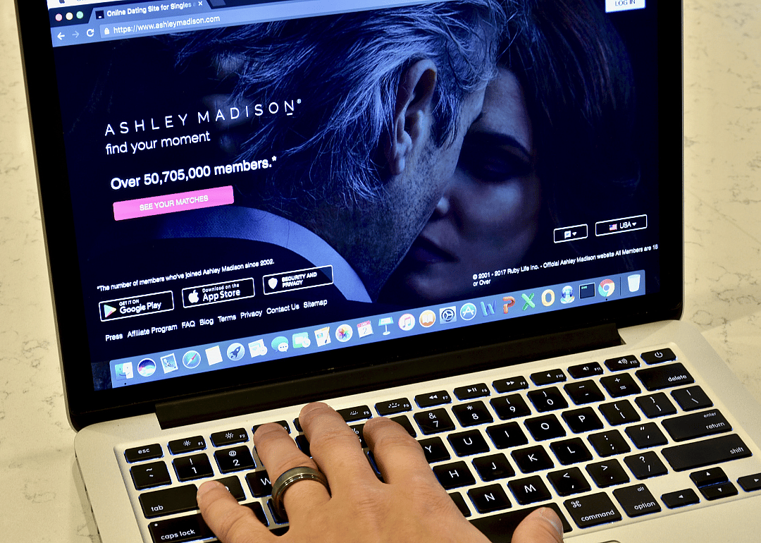 An Apple Macbook Pro displaying the Ashley Madison website while a married person browses.