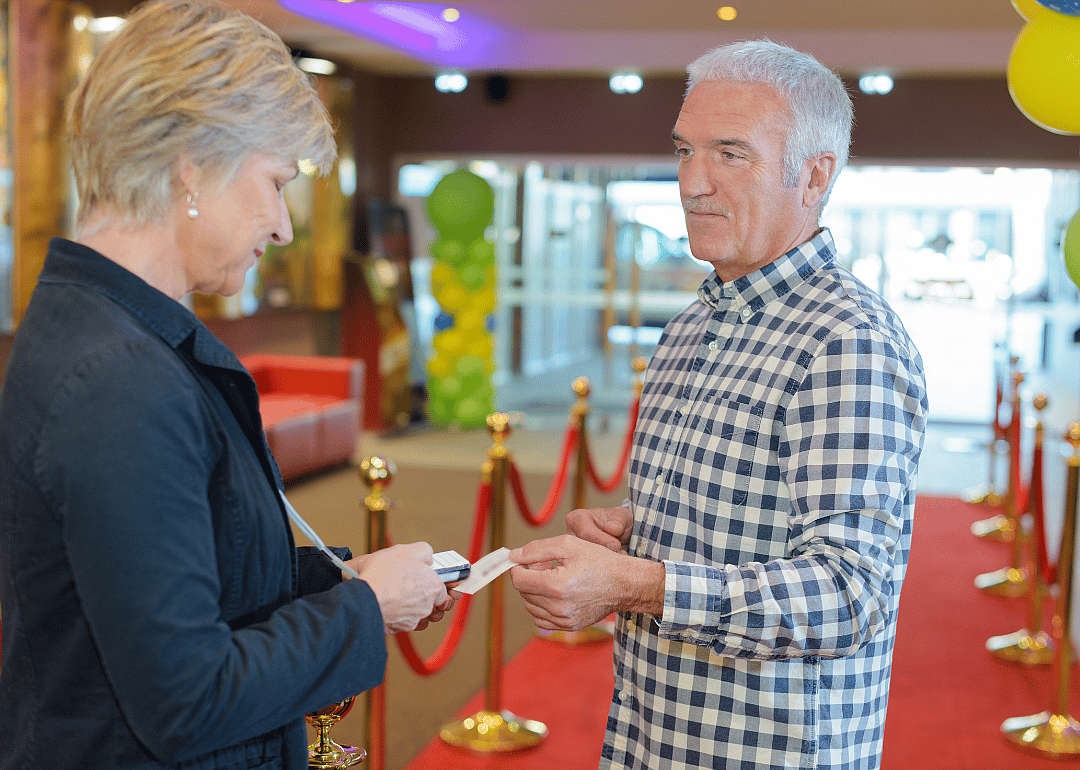 A man gives a ticket to an entertainment attendant.