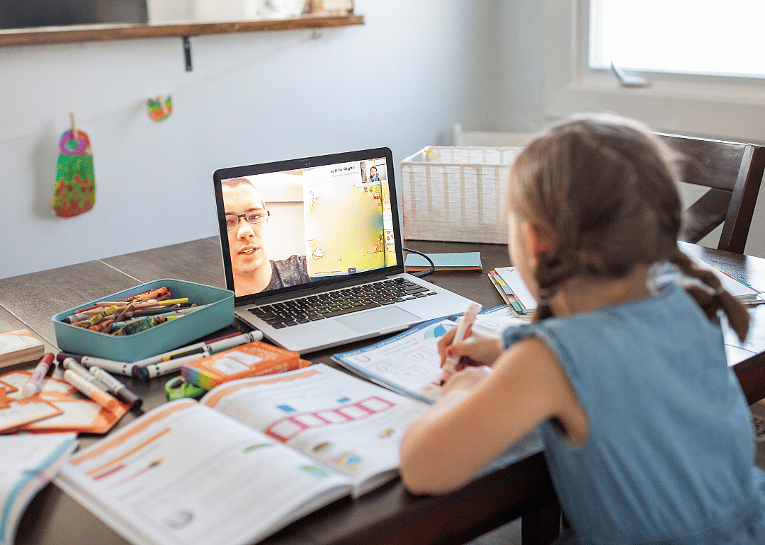 A young girl using her laptop to learn remotely