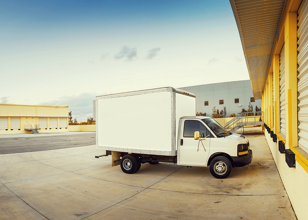A light truck parked in front of a storage locker.