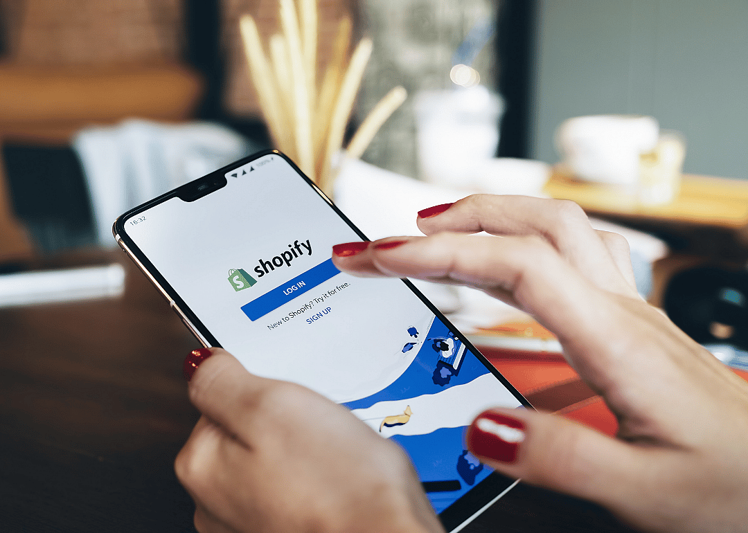 A phone open to the Shopify login screen