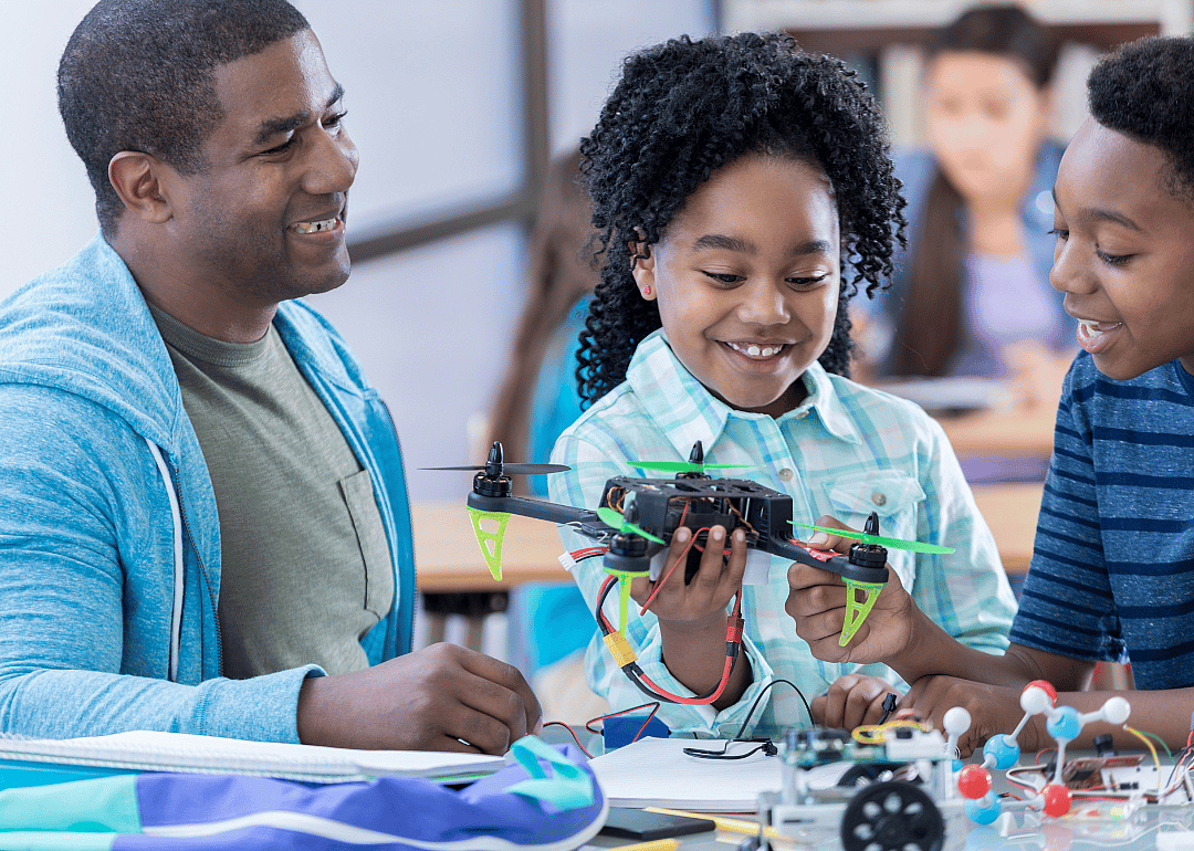 Middle school students and their teacher building a drone.