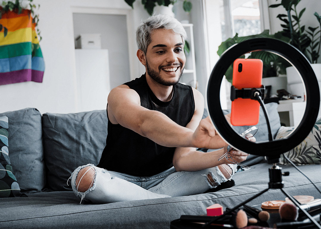 An influencer does his makeup while sharing products with his viewers