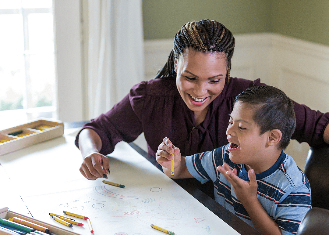 A teacher working with an excited special needs student.