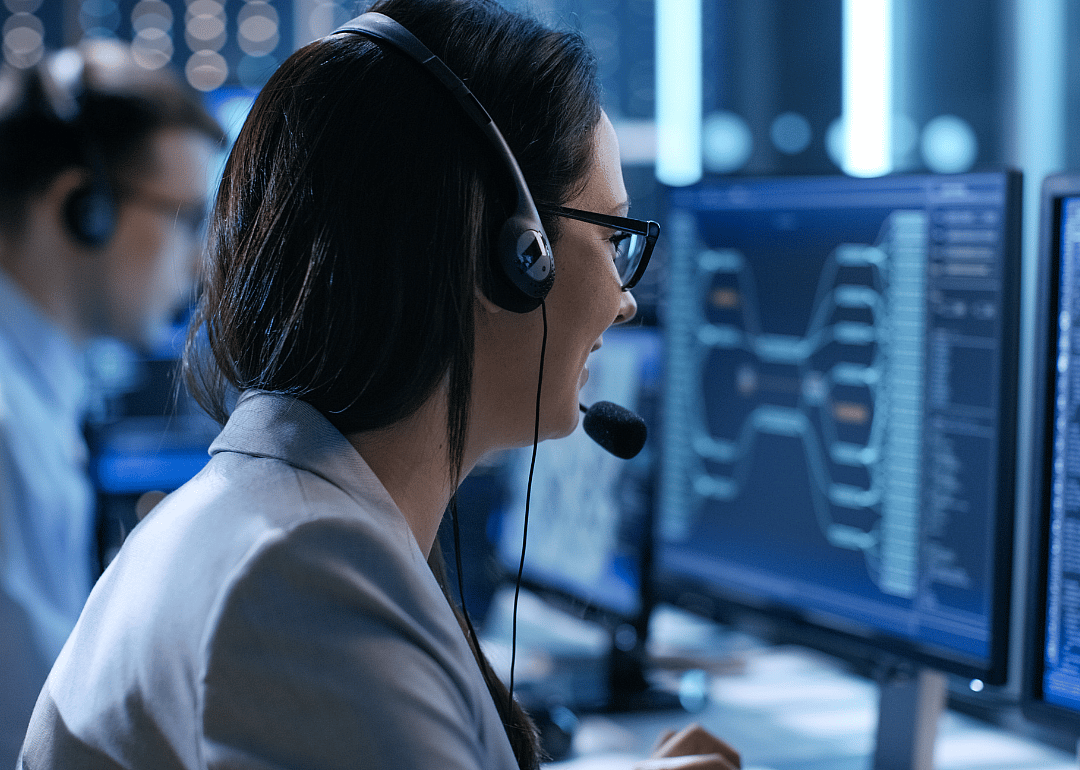 A woman with a headset in front of a computer.