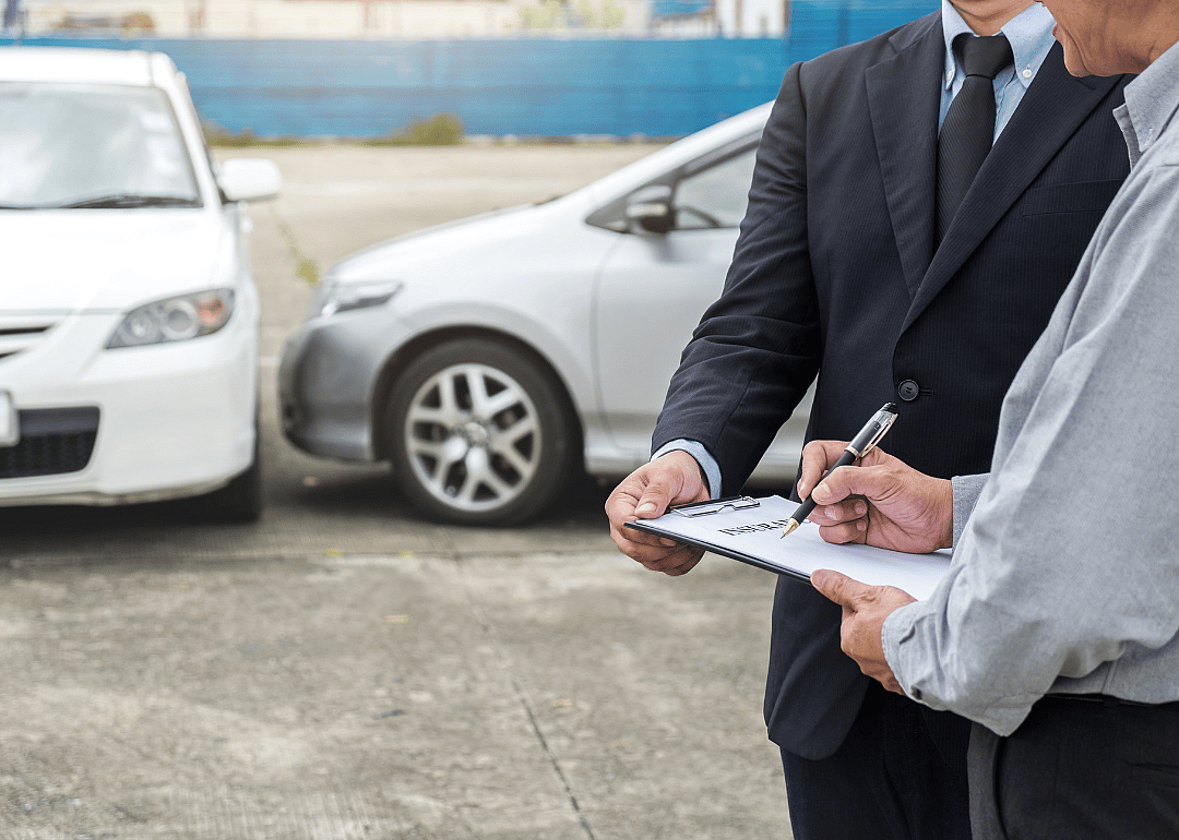 A person filling out an insurance claim after an accident.