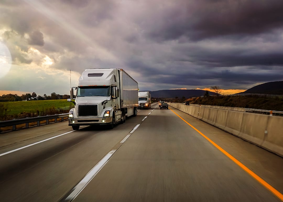 Two 18-wheelers on a highway platooning.