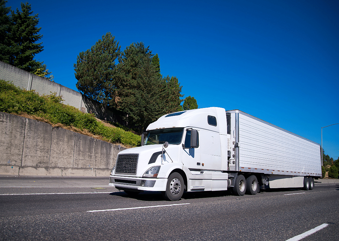 A Class 8 truck driving on a highway road.