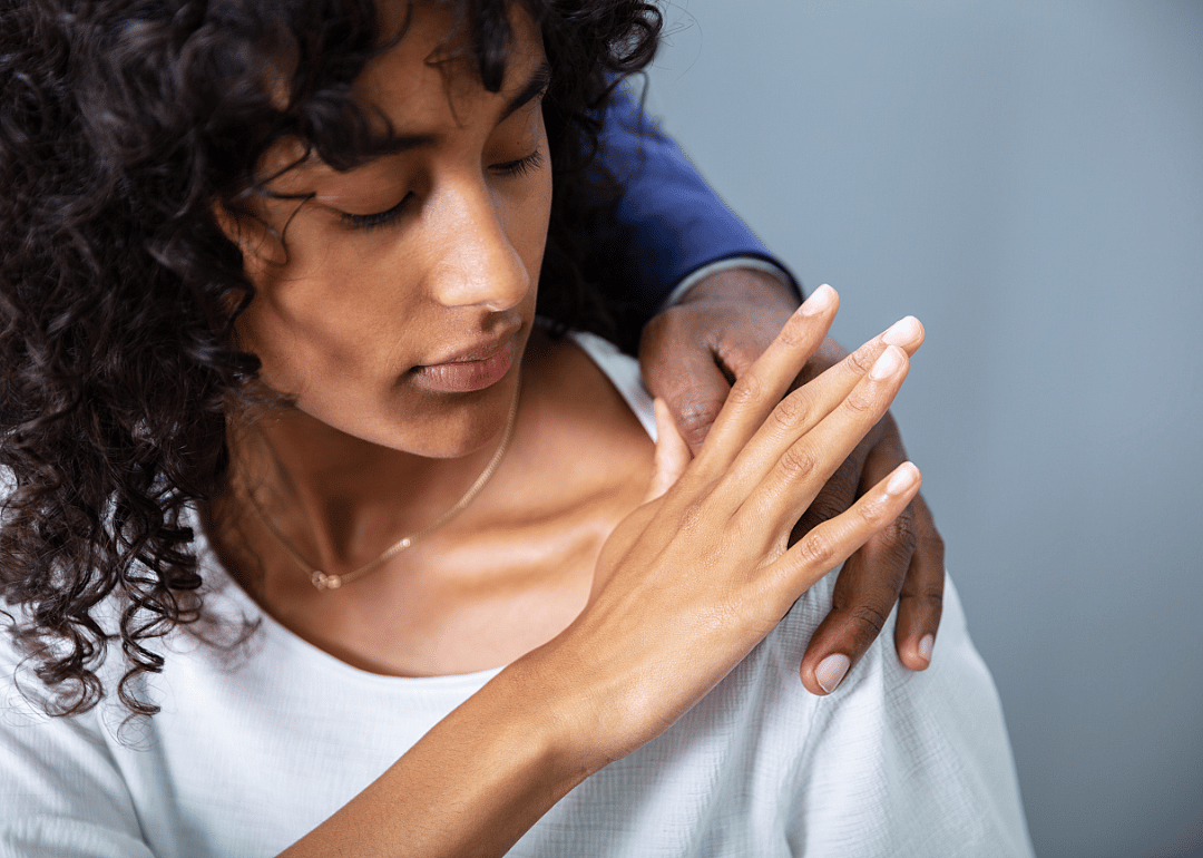 A businessperson removing a coworkers hand from their shoulder.