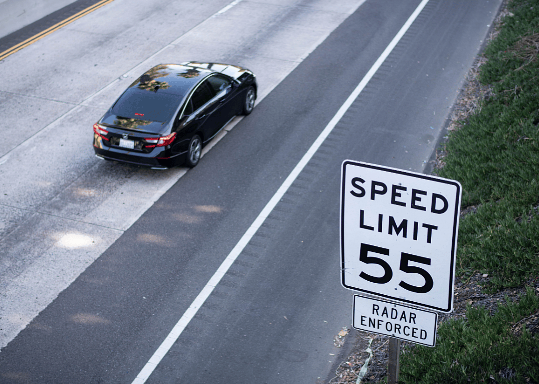 A car driving down an interstate with a 55 mph speed limit.