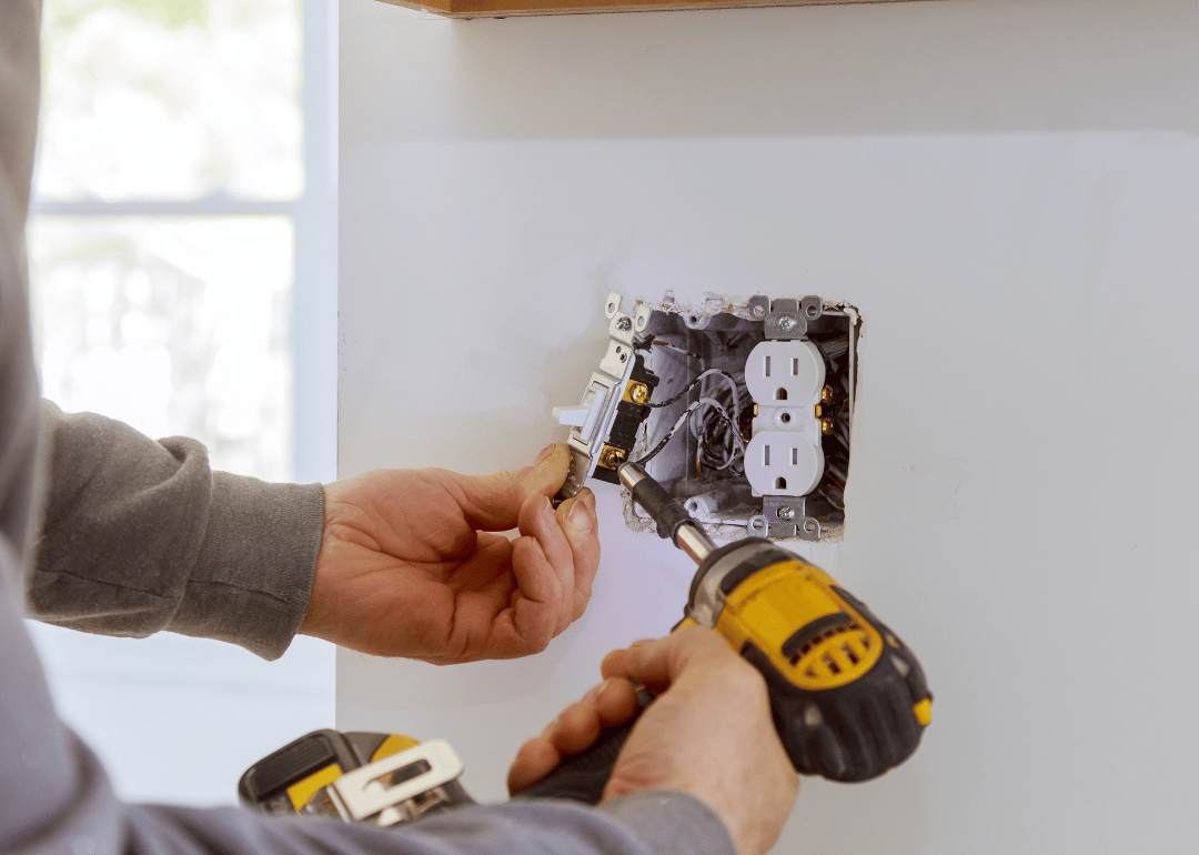 A person installing electrical outlets