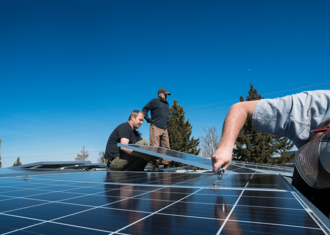 Workers installing solar panels on a home's roof.