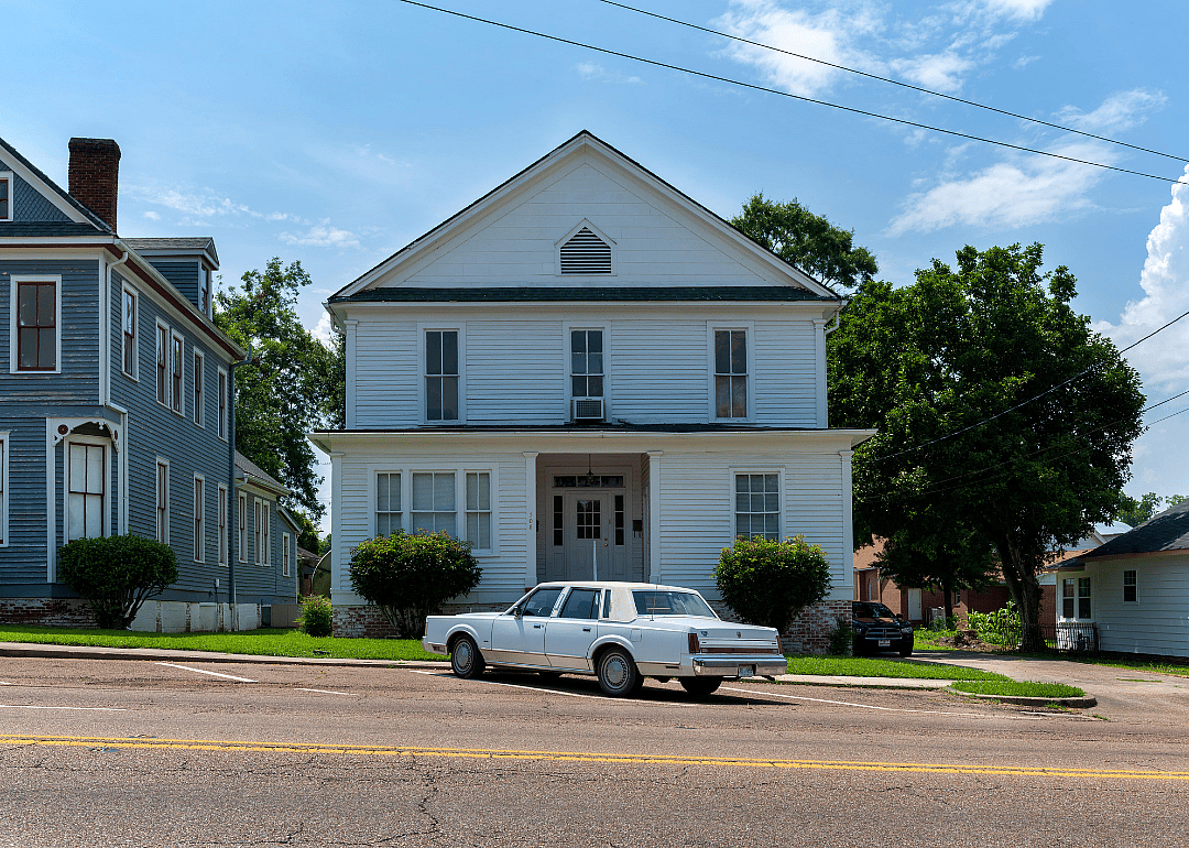A vintage car parkerd in front of a wood house in Vicksburg, Mississippi.