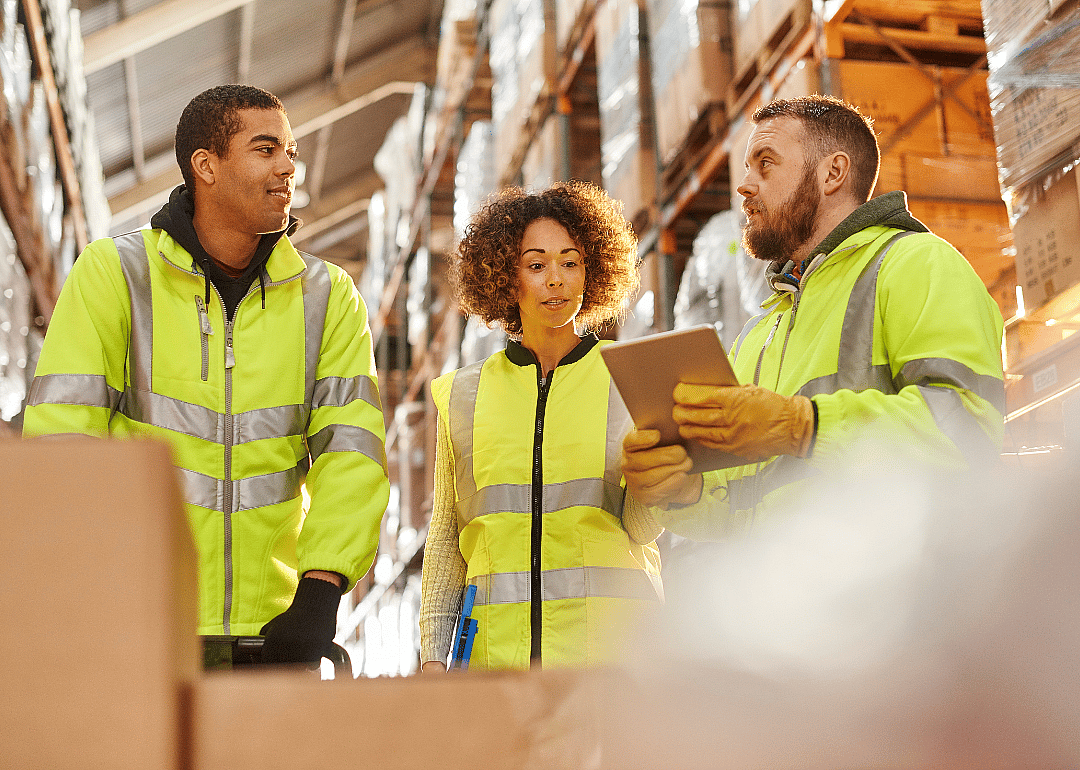 Warehouse workers speaking with a supervisor.