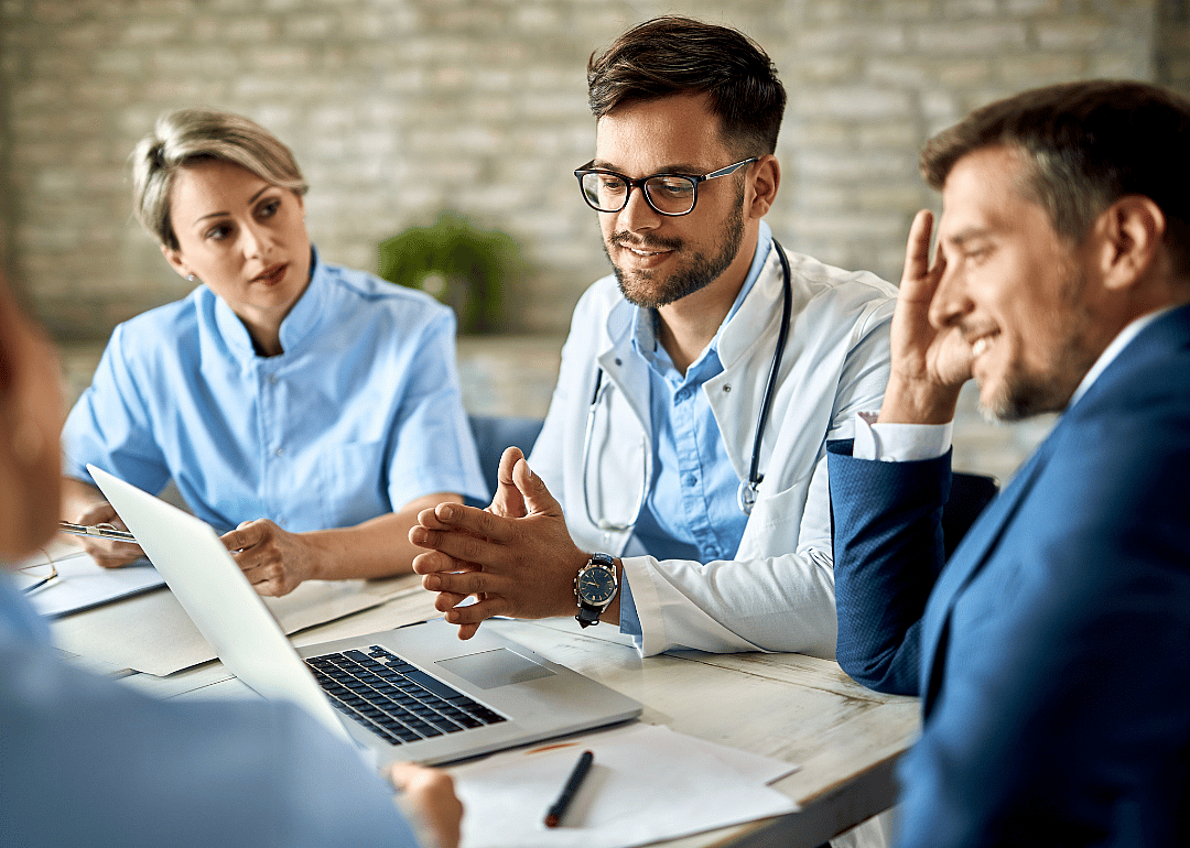 A doctor meeting with medical managers dressed in business clothes.
