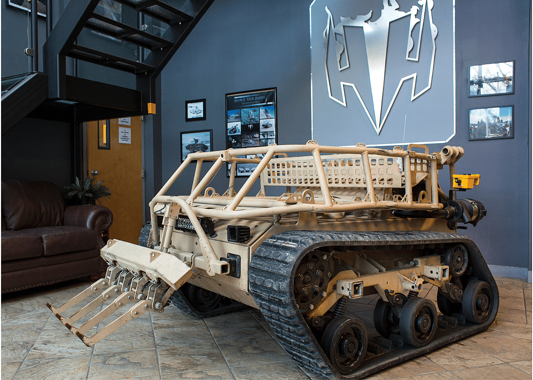 A relatively small military tank robot on display in a building.