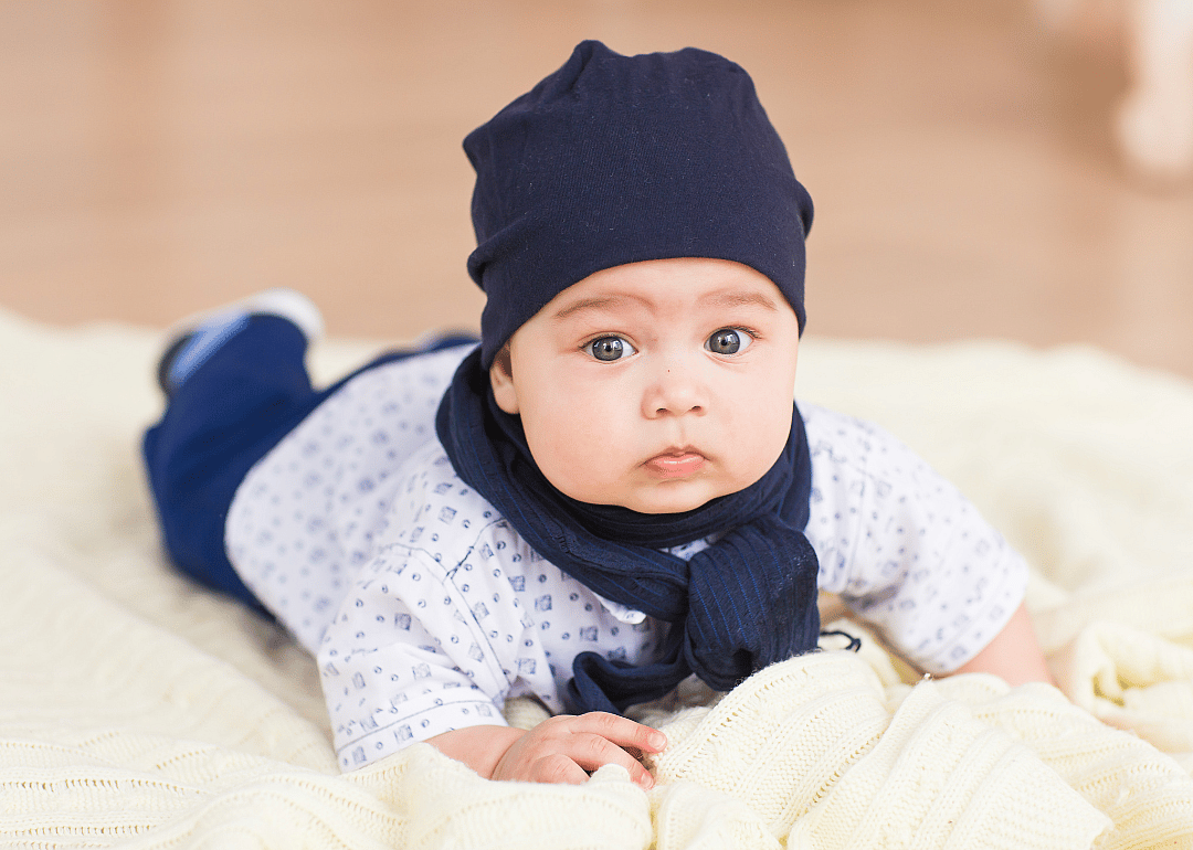 A baby boy with blue eyes and blue hat. 