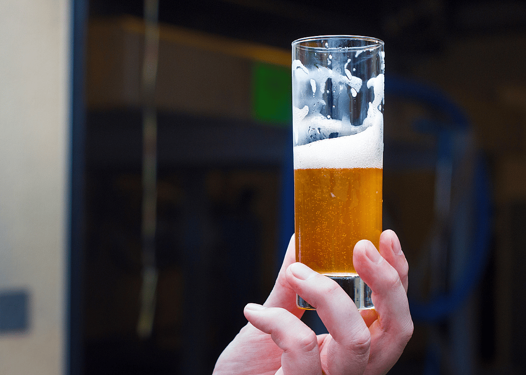 Hand holding glass of beer.