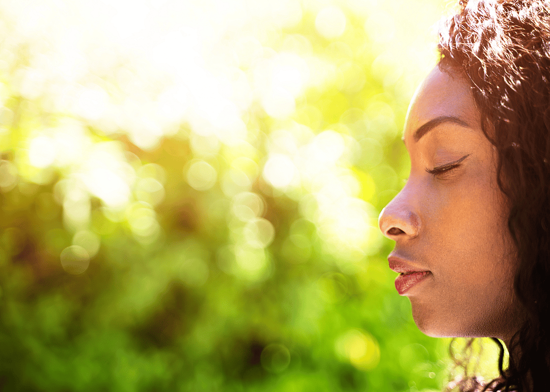 A woman taking a breath with her eyes closed.