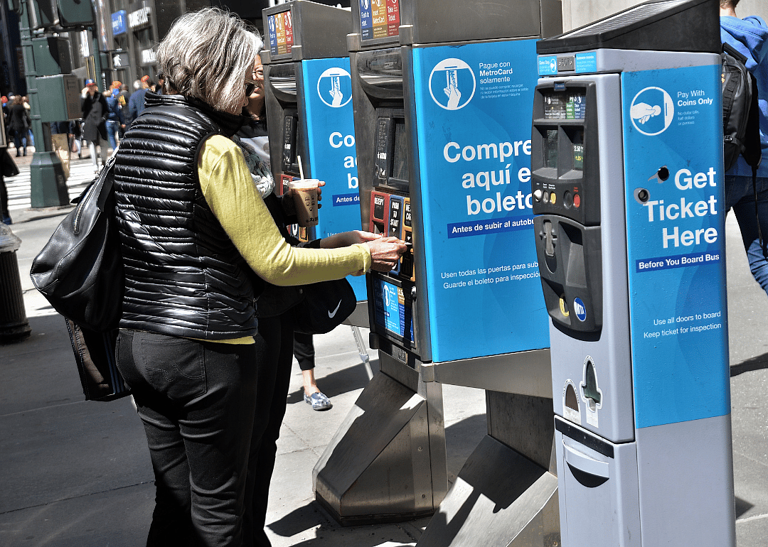A person using a bus fare machine outside for the MTA in New York City.