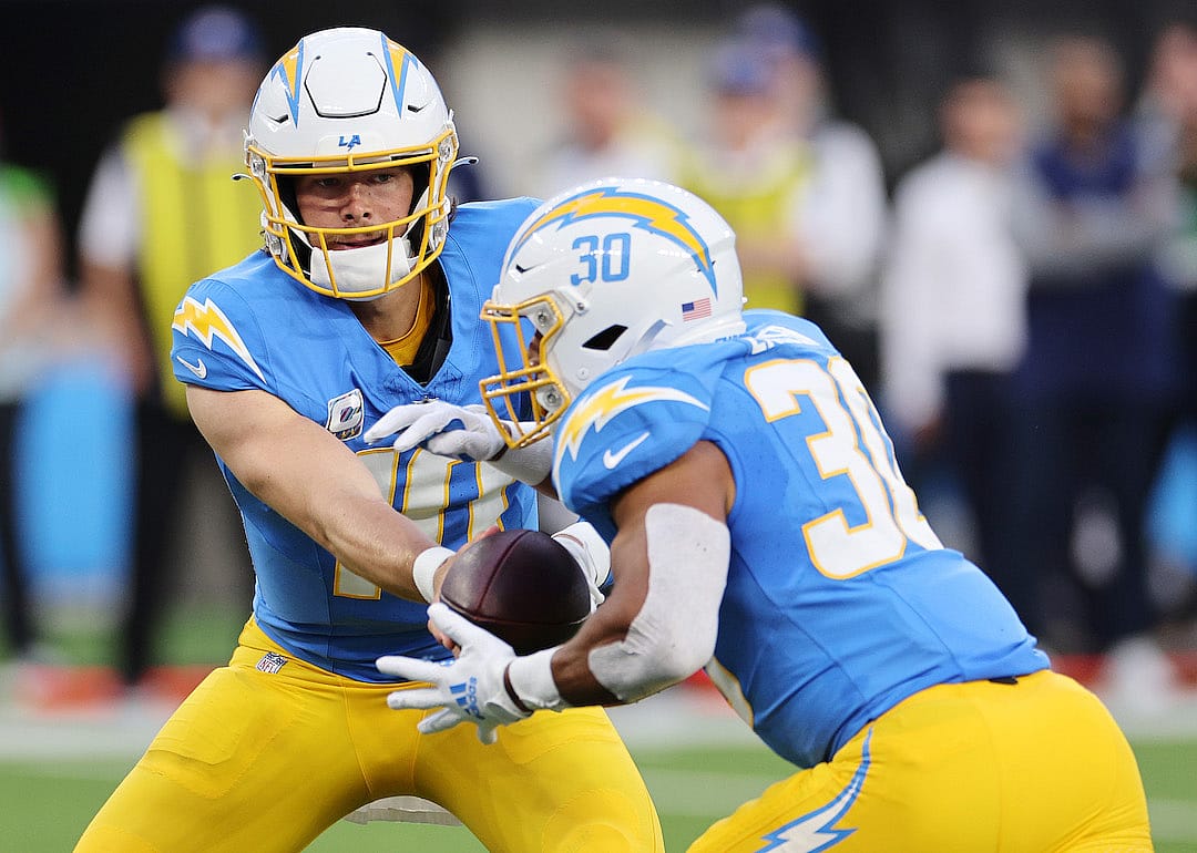 Justin Herbert hands off to Austin Ekeler of the Los Angeles Chargers in the first half against the Dallas Cowboys at SoFi Stadium on Oct. 16, 2023 in Inglewood, California.