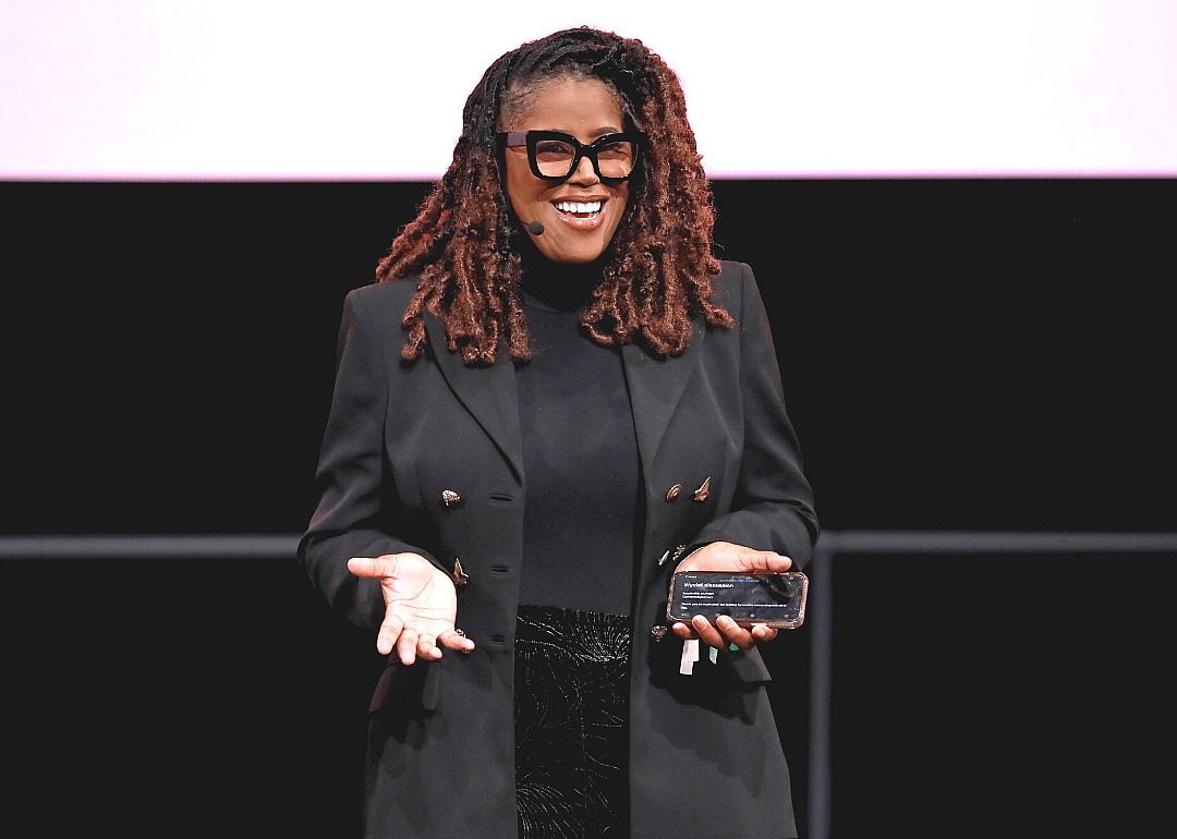 Thasunda Duckett presenting in front of a black and pink background.