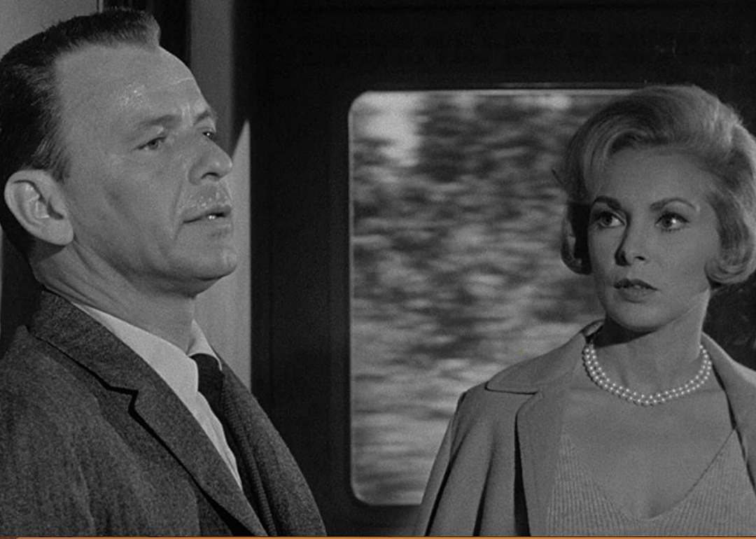 Frank Sinatra looks worried as a woman looks at him.