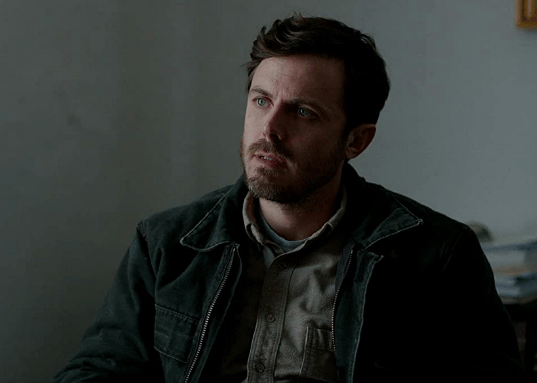 Casey Affleck sitting in a chair.