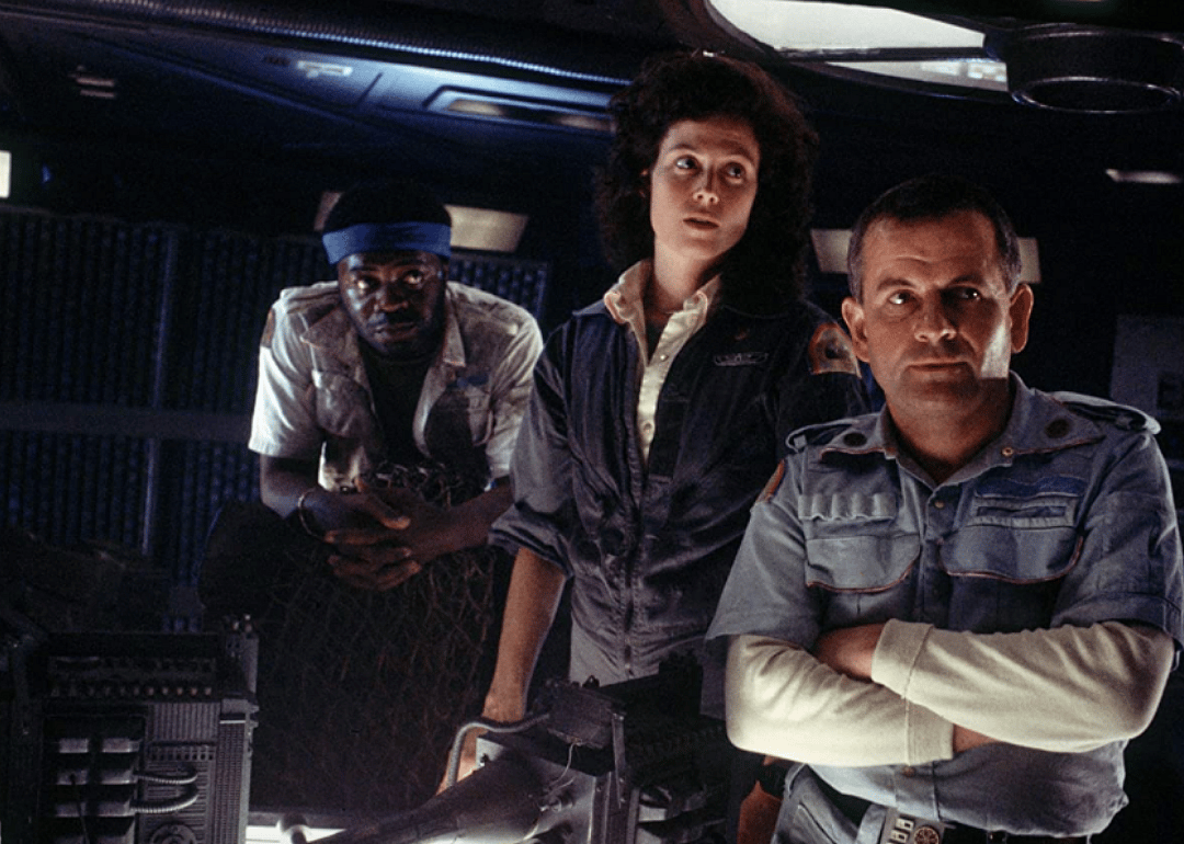 Sigourney Weaver and two men inside a space craft.