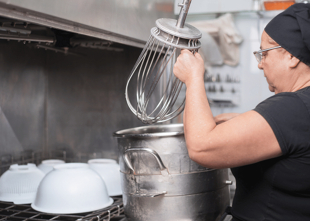 A dishwasher cleans a pot.