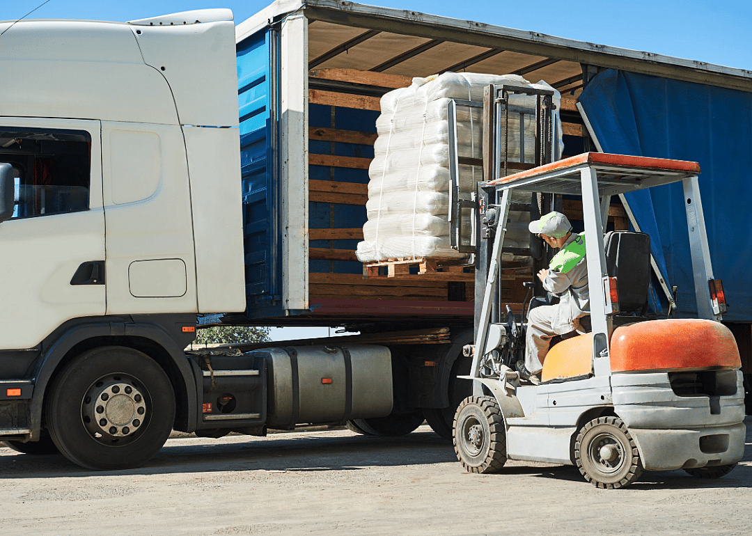 A worker loads material on a truck