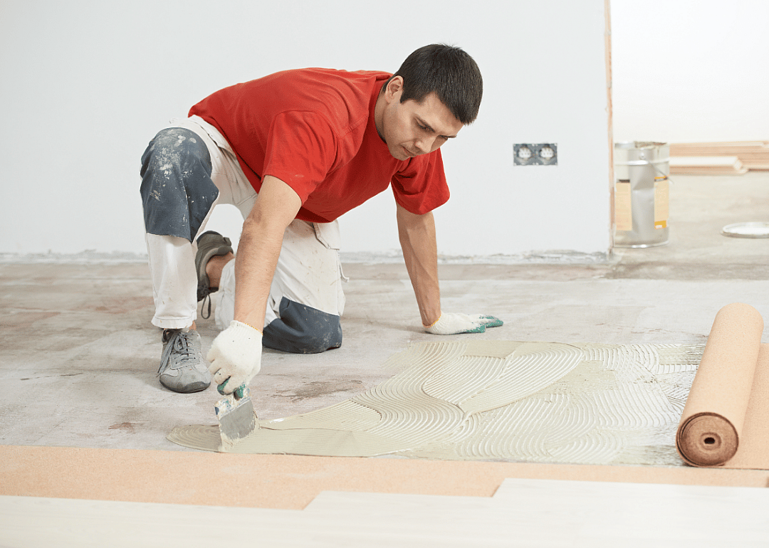 A tile layers works on a floor