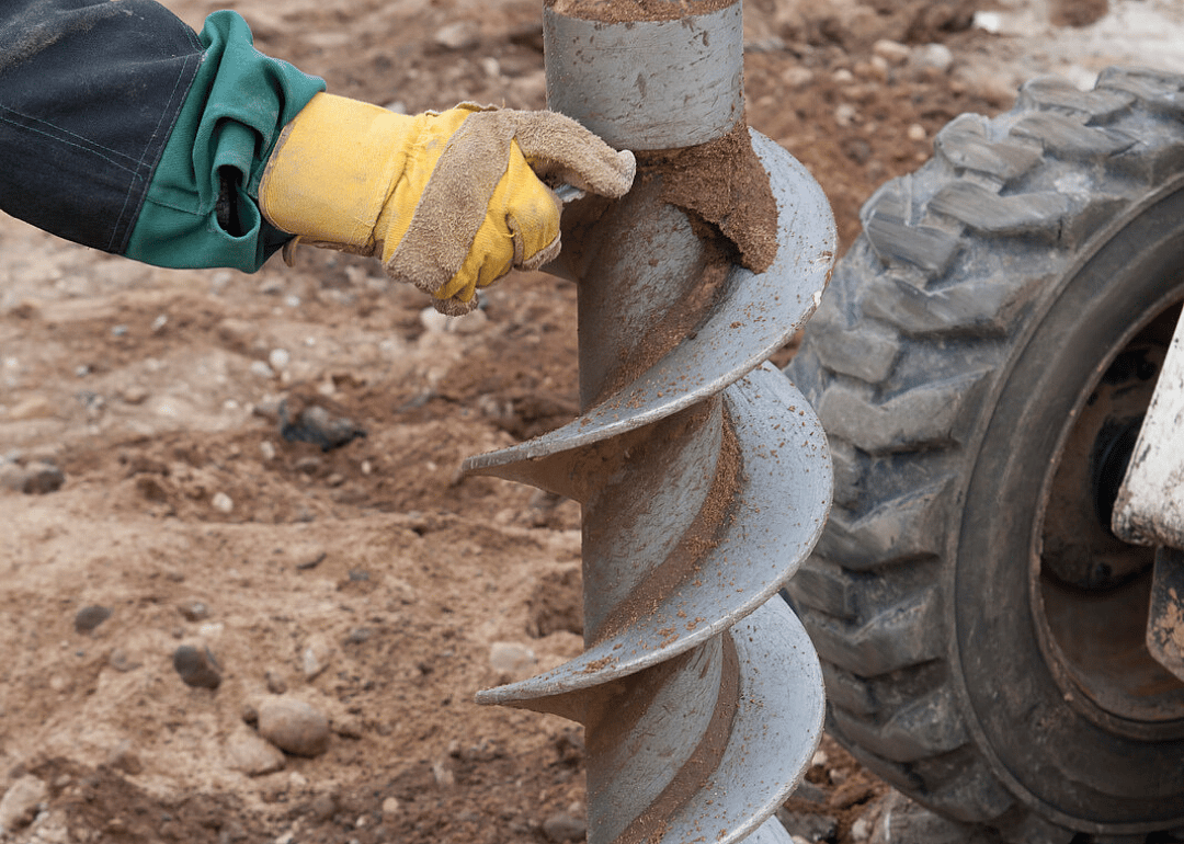Drill operator holds a large drilling tool