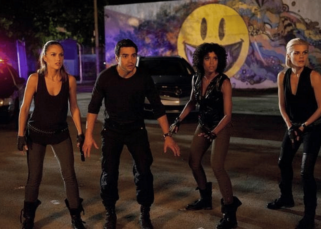 Three women and a man dressed in black stand ready.