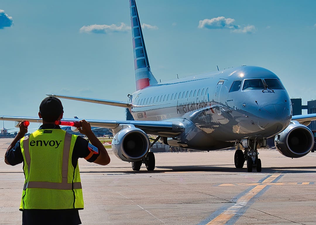 Envoy ramp workers bringing a jet to the gate.