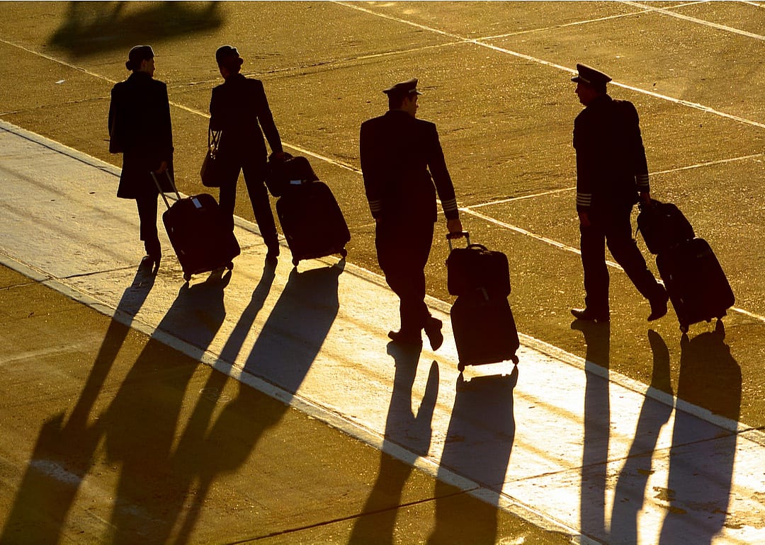 Crew walking on runway to plane.