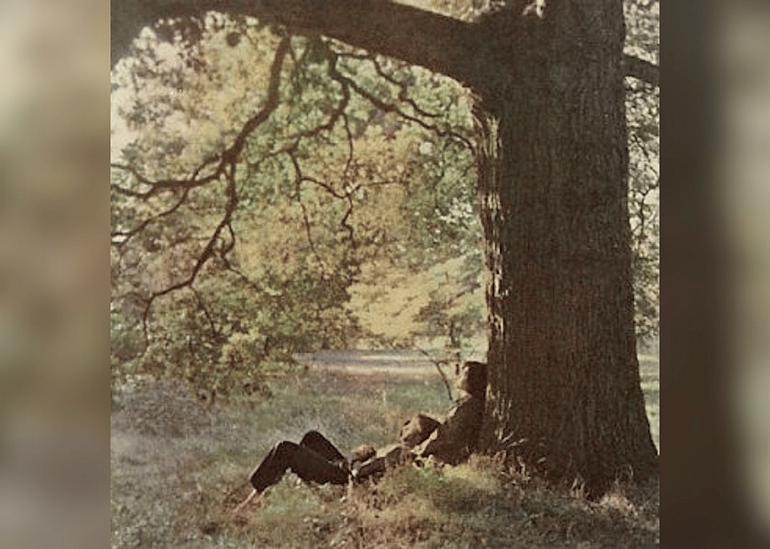John Lennon and Yoko Ono sitting under a tree.